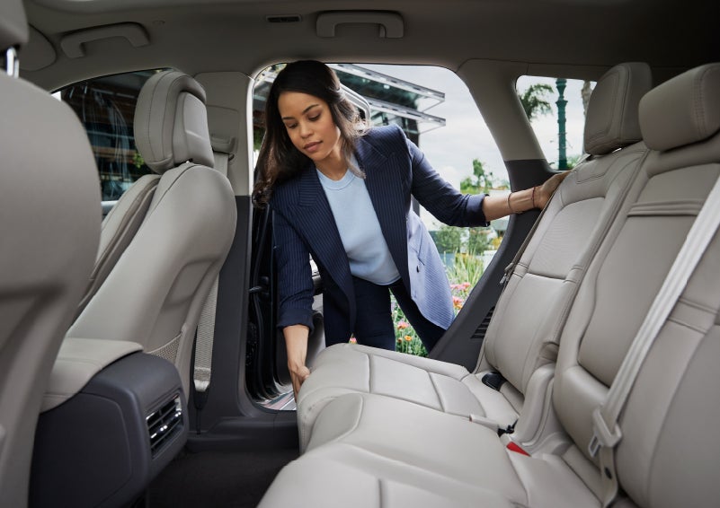A woman slides the second-row seat forward to create more cargo space | Fair Oaks Lincoln in Naperville IL